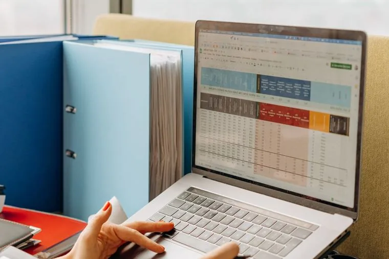 A laptop with a spreadsheet open beside stacked folders, the Basic seat in a browser