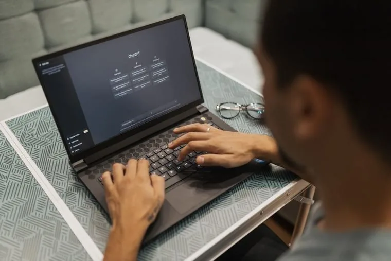 Hands typing on a laptop as mail from the old provider is migrated into Exchange