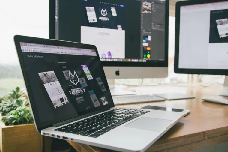 A laptop and monitor on a clean desk, the Singapore hotline on the other end