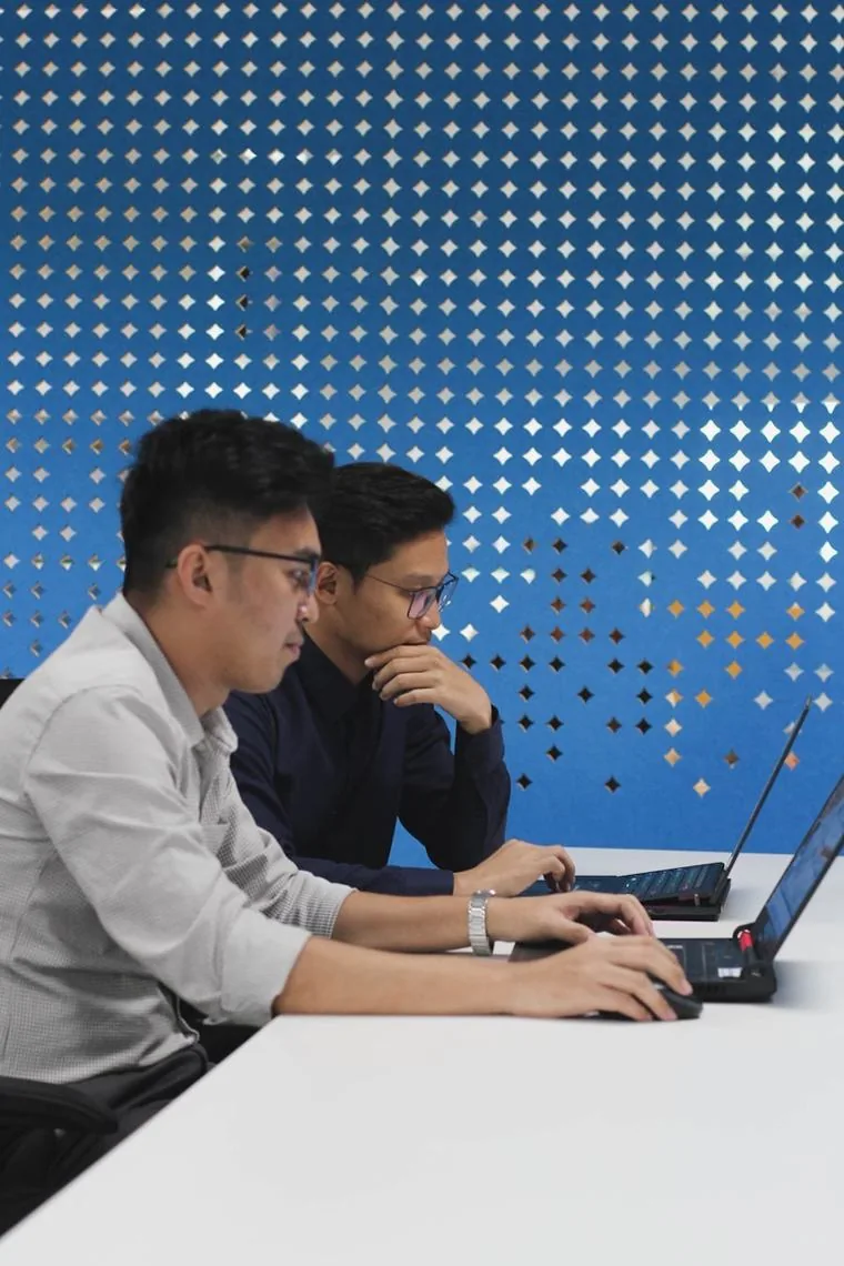 Two engineers reviewing privilege and access on a Singapore client system