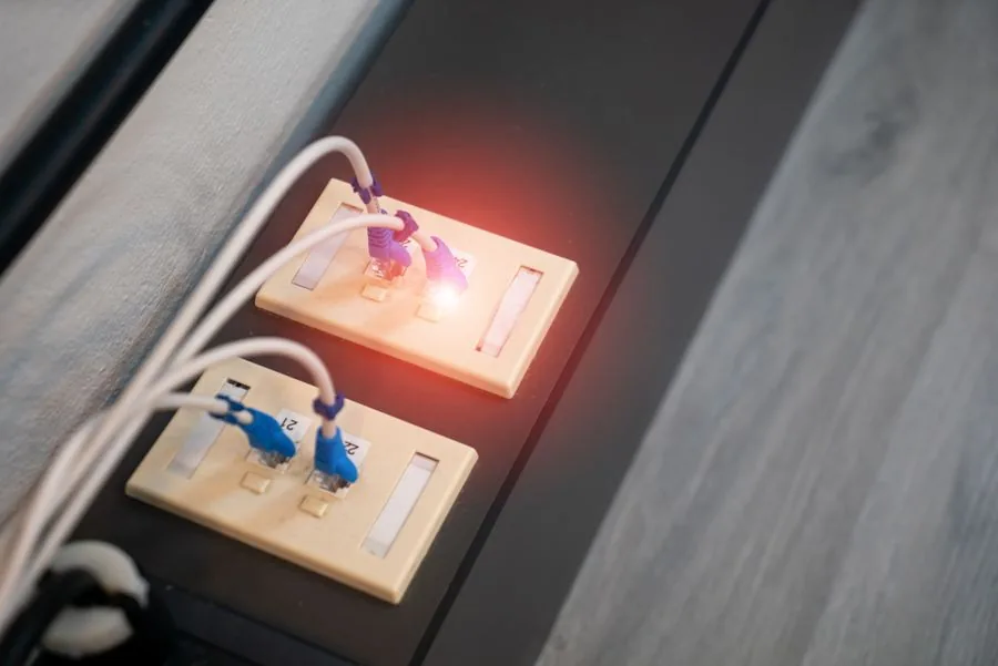 Wall data outlet with two patch leads, one port showing a lit link indicator