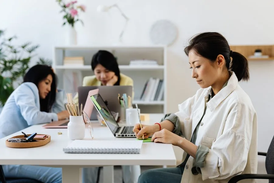 Three colleagues reviewing a rollout plan together at an office table