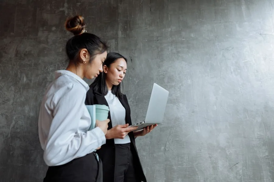 Two colleagues reviewing a network plan on a laptop before an office fit-out